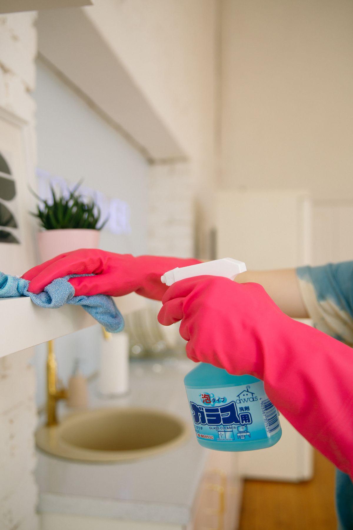 Gloved hands wiping down a surface during a deep clean