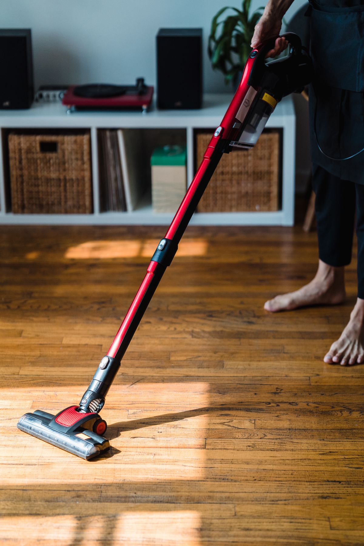Vacuuming a wooden floor in a sunlit room